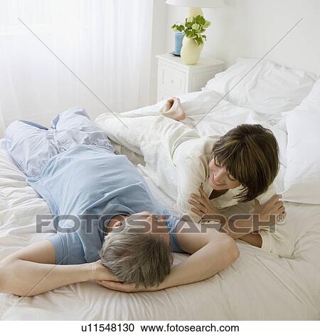 Couple laying on bed View Large Photo Image Stock Image - Couple laying on bed. Fotosearch