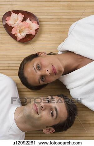 Couple laying on floor next to flowers View Large Photo Image Stock Image - Couple laying on floor next to flowers. Fotosearch