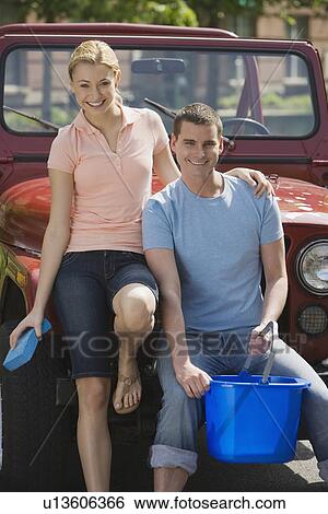 Stock Photograph - Couple leaning on jeep. Fotosearch