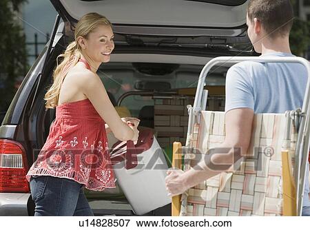 Couple loading vacation items into truck View Large Photo Image Stock Photo - Couple loading vacation items into truck. Fotosearch