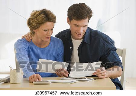 Stock Photo - Couple looking at bills. Fotosearch