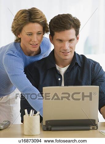 Picture - Couple looking at laptop. Fotosearch