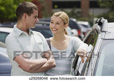 Stock Photograph - Couple looking at new car. Fotosearch