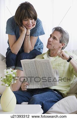 Couple looking at newspaper View Large Photo Image Stock Image - Couple looking at newspaper. Fotosearch