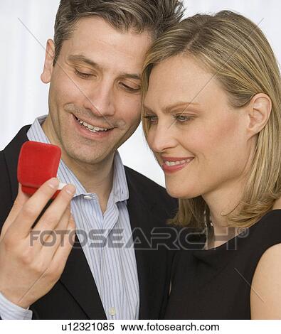 Stock Photography - Couple looking at ring box. Fotosearch