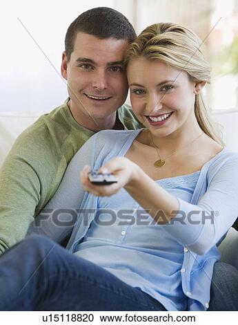 Couple of sofa pointing remote control View Large Photo Image Stock Image - Couple of sofa pointing remote control. Fotosearch