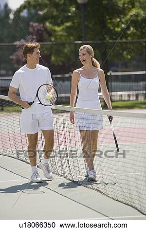 Stock Image - Couple on tennis court. Fotosearch