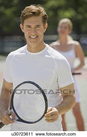 Stock Image - Couple on tennis court. Fotosearch