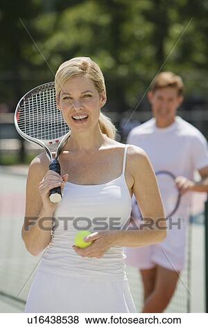 Stock Photo - Couple on tennis court. Fotosearch