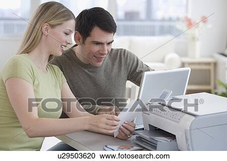 Couple printing picture with laptop View Large Photo Image Stock Image - Couple printing picture with laptop. Fotosearch