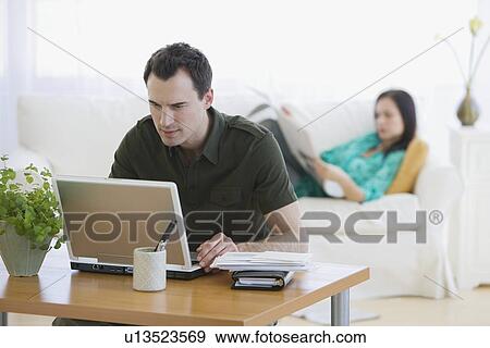 Stock Photo - Couple relaxing in living room. Fotosearch