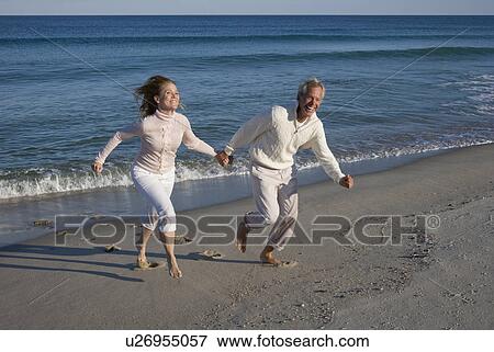 Stock Photo - Couple running on beach. Fotosearch