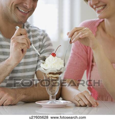 Couple sharing ice cream sundae View Large Photo Image Stock Photo - Couple sharing ice cream sundae. Fotosearch