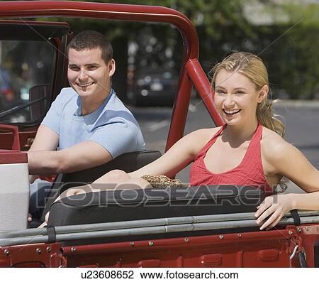 Stock Image - Couple sitting in jeep. Fotosearch