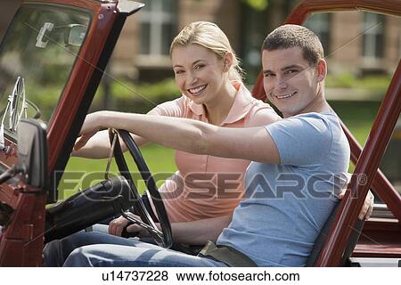 Stock Photo - Couple sitting in jeep. Fotosearch