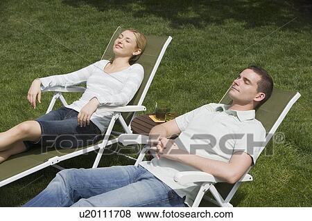 Stock Photo - Couple sitting in lounge chairs. Fotosearch