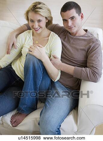 Stock Photo - Couple sitting on sofa. Fotosearch