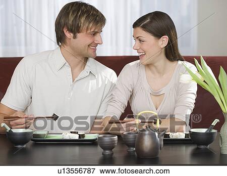 Couple smiling at each other at Japanese restaurant View Large Photo Image Stock Photo - Couple smiling at each other at Japanese restaurant. Fotosearch