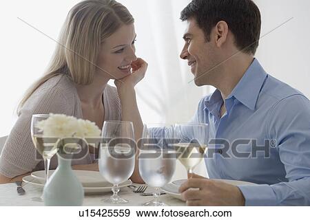 Couple smiling at each other in restaurant View Large Photo Image Stock Photo - Couple smiling at each other in restaurant. Fotosearch