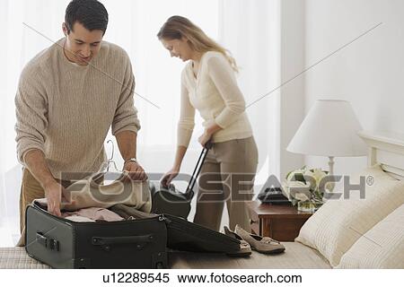 Couple unpacking in hotel room View Large Photo Image Stock Photography - Couple unpacking in hotel room. Fotosearch