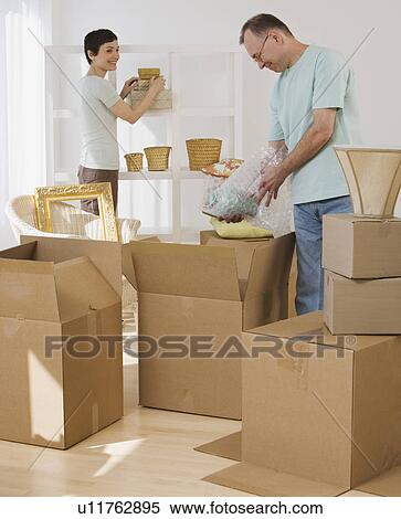 Couple unpacking moving boxes View Large Photo Image Stock Photography - Couple unpacking moving boxes. Fotosearch