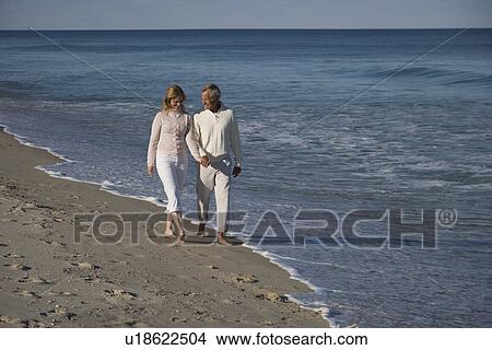 Couple walking on beach View Large Photo Image Picture - Couple walking on beach. Fotosearch