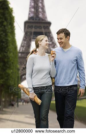 Stock Image - Couple walking with Eiffel Tower in background. Fotosearch