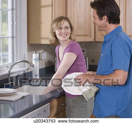 Stock Image - Couple washing dishes. Fotosearch