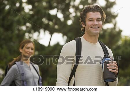 Couple wearing backpacks in woods View Large Photo Image Stock Image - Couple wearing backpacks in woods. Fotosearch