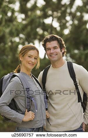 Stock Photo - Couple wearing backpacks in woods. Fotosearch