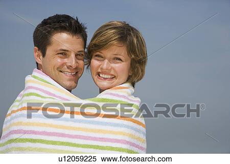 Couple wrapped in beach towel View Large Photo Image Stock Photography - Couple wrapped in beach towel. Fotosearch
