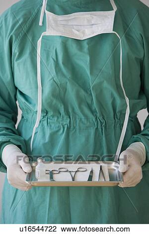Doctor holding tray of medical instruments View Large Photo Image Stock Image - Doctor holding tray of medical instruments. Fotosearch
