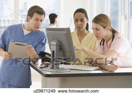 Doctors looking at computer in hospital View Large Photo Image Stock Photo - Doctors looking at computer in hospital. Fotosearch