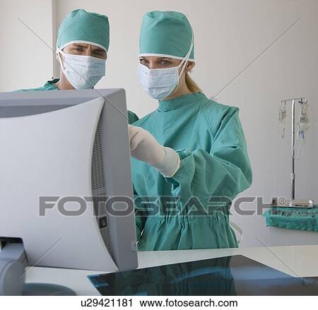 Doctors looking at computer monitor View Large Photo Image Stock Image - Doctors looking at computer monitor. Fotosearch