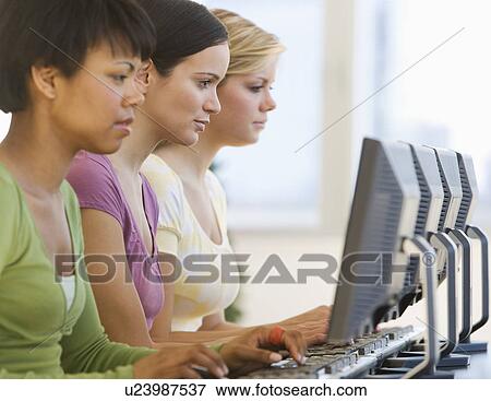 Stock Photo - Ethnic-ethnic women typing on computers. Fotosearch