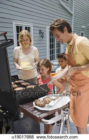 Family barbequing on deck View Large Photo Image Stock Photo - Family barbequing on deck. Fotosearch