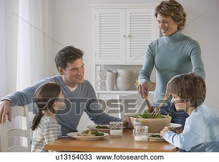 Family eating at dinner table View Large Photo Image Stock Image - Family eating at dinner table. Fotosearch