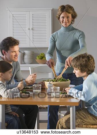 Stock Image - Family eating at dinner table. Fotosearch
