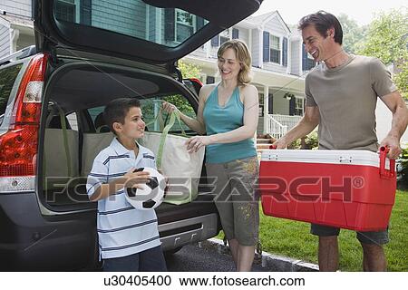 Stock Image - Family loading car for picnic. Fotosearch