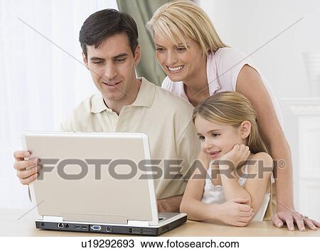 Stock Image - Family looking at laptop. Fotosearch