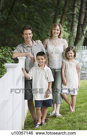 Family next to fence in yard View Large Photo Image Stock Photograph - Family next to fence in yard. Fotosearch