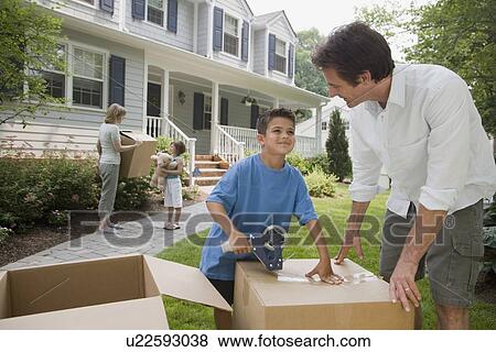 Stock Photo - Family packing moving boxes. Fotosearch