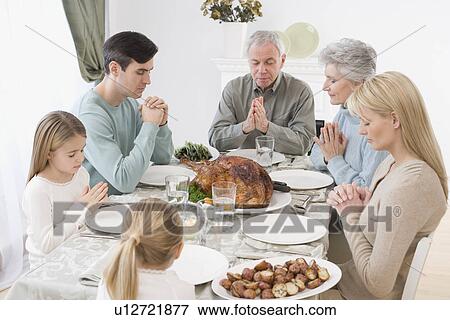 Family saying grace at Thanksgiving table View Large Photo Image Stock Photo - Family saying grace at Thanksgiving table. Fotosearch