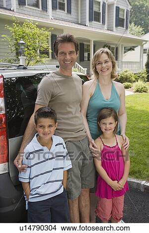 Picture - Family standing behind car. Fotosearch