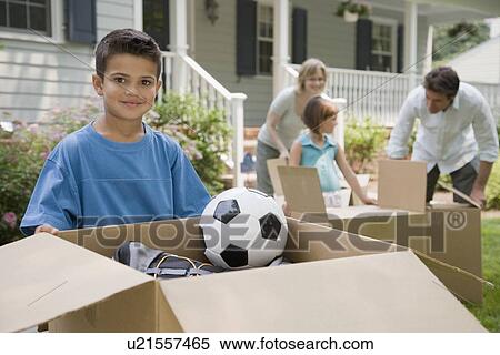 Stock Photography - Family unpacking moving boxes. Fotosearch