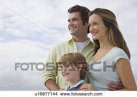 Picture - Family with one child under cloudy sky. Fotosearch