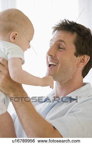 Father and baby smiling at each other View Large Photo Image Stock Photograph - Father and baby smiling at each other. Fotosearch