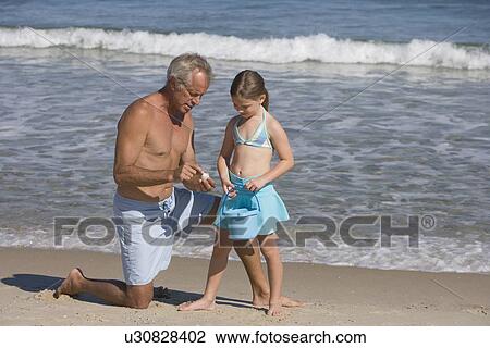Stock Image - Father and daughter at beach. Fotosearch
