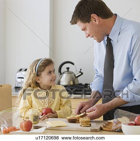 Stock Photo - Father and daughter making breakfast. Fotosearch