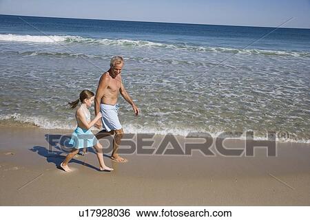 Father and daughter walking on beach View Large Photo Image Stock Photograph - Father and daughter walking on beach. Fotosearch